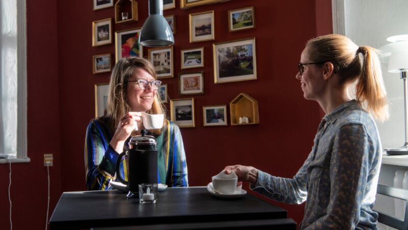 To kvinder sidder og drikker kaffe i caféen på Brundlund Slot