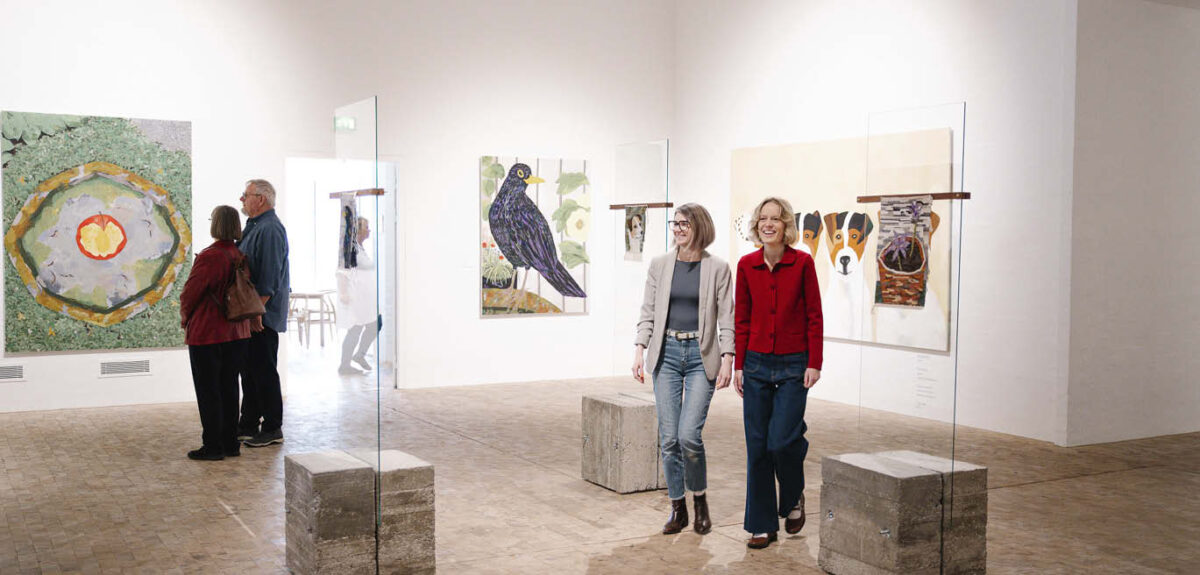 Ein Ehepaar und zwei junge Frauen befinden sich in der Sonderausstellung mit Werken von Anette Abrahamsson im Kunstmuseum Tondern.
