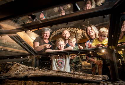 A family is looking at the fossils on display in the exhibition at Gram Clay Pit
