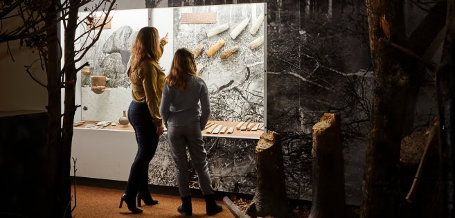 Eine Frau und Tochter betrachteten verscheidende archäologische Funde