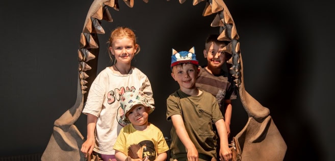 Vier Kinder stehen in einer Replikation des Rachens des Riesenhais Megalodon