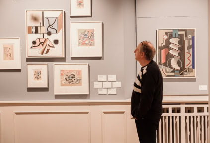 Ein Mann betrachtet die Kunstwerke von Franciska Clausen im Kunstmuseum Schloss Brundlund