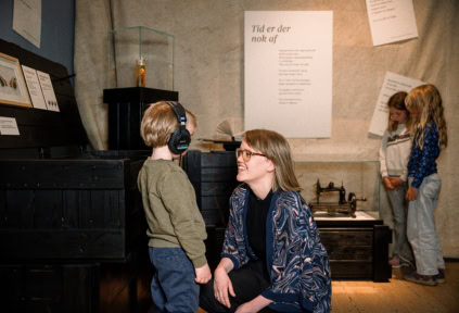 Eine Frau, ein Junge und zwei Mädchen in der Ausstellung in Kulturgeschichte in Apenrade