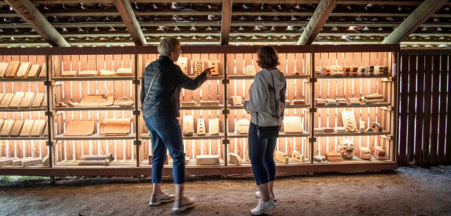 Zwei Frauen betrachten die Ziegel bei der Ziegelei Cathrinesminde