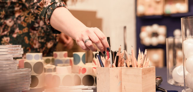 Bleistifte, Stickers und weitere Materialen stehen auf einem Tisch
