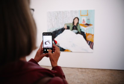 A woman is taking a photo of an artwork at the Art Museum in Tønder